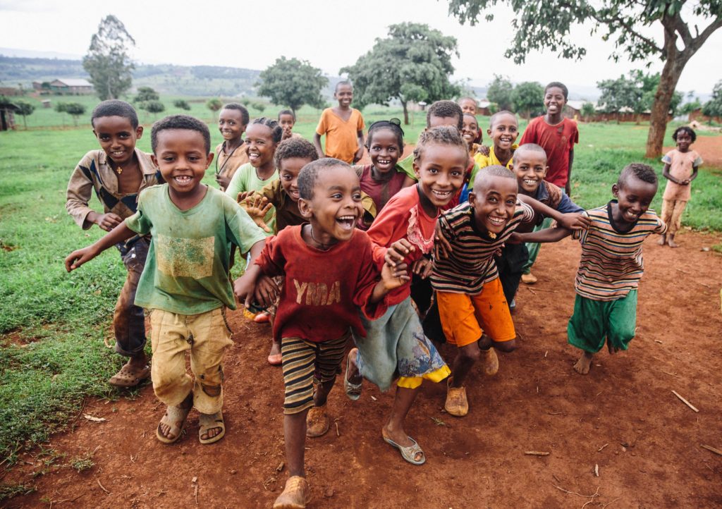 Young children run in excitement toward the camera.