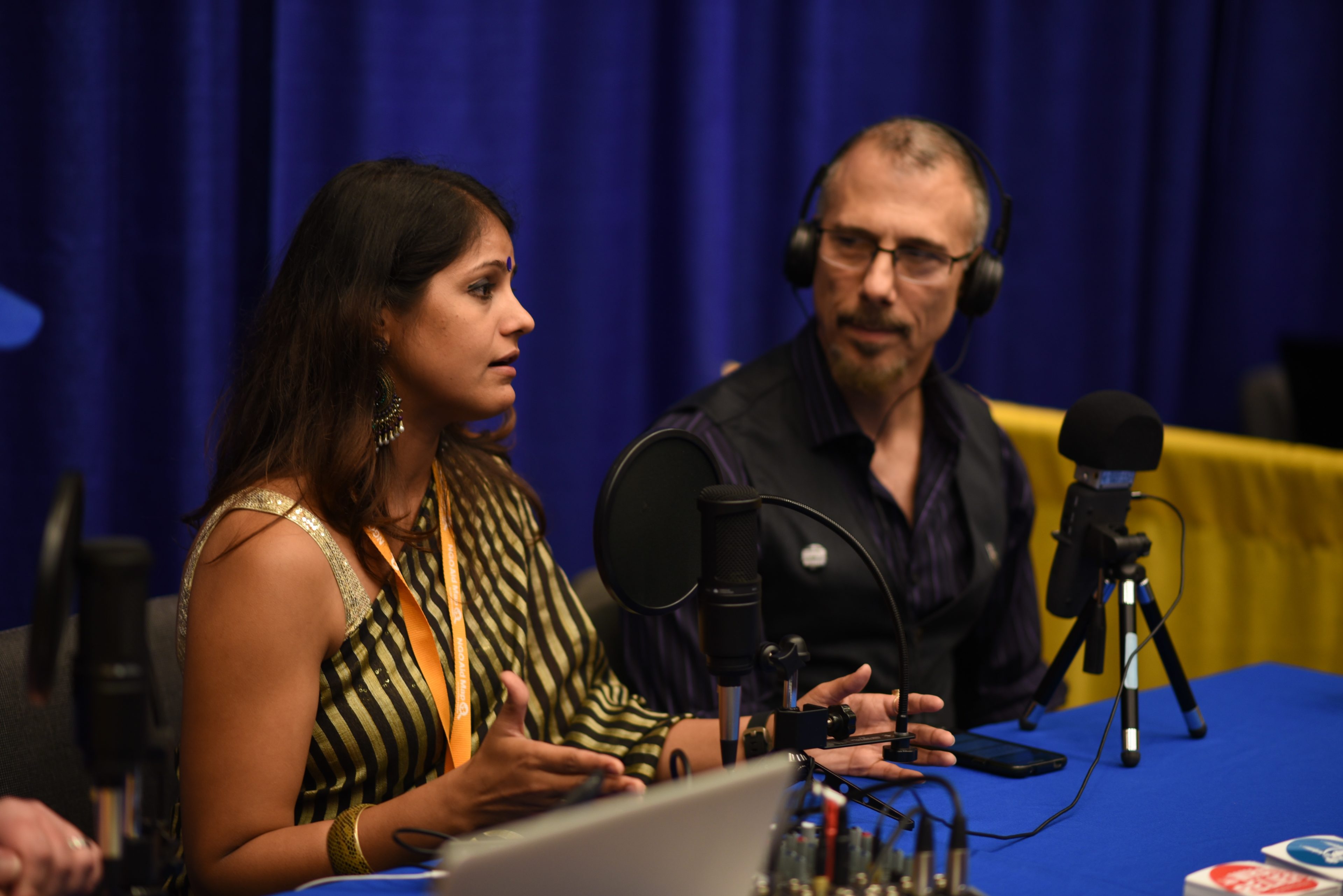 a woman and a man talk during a podcast recording