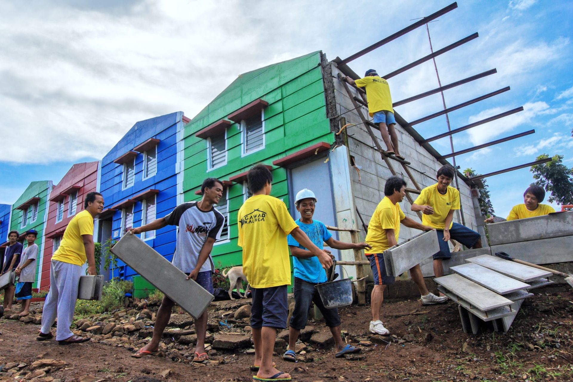 A group of people pass construction materials to each other as a new house is being built