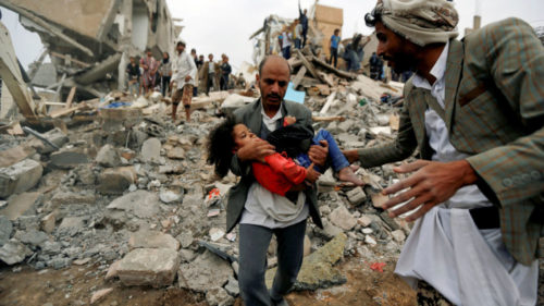 A man caries a chirldren during the Yemen Crisis