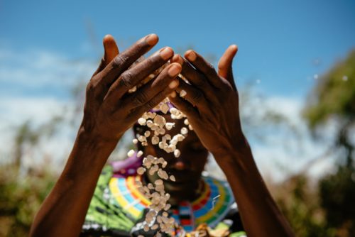 close up of woman letting corn spill through her hands.