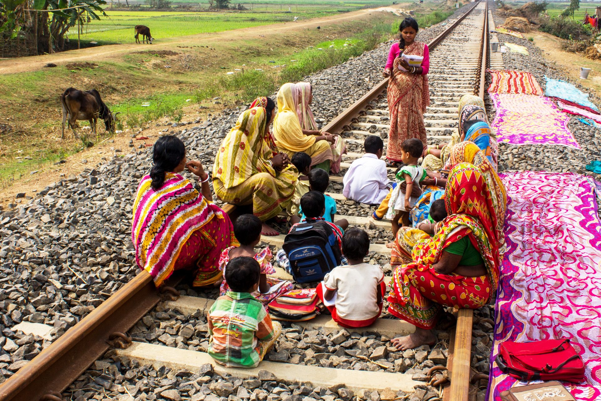 Women teaches women and children on a train track.