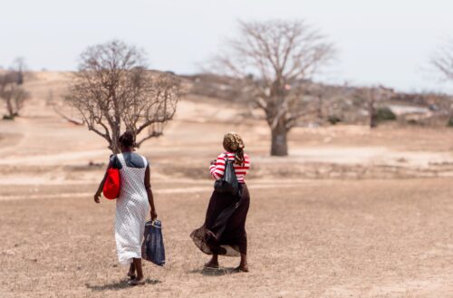 Two women walk side by side in rural Angola